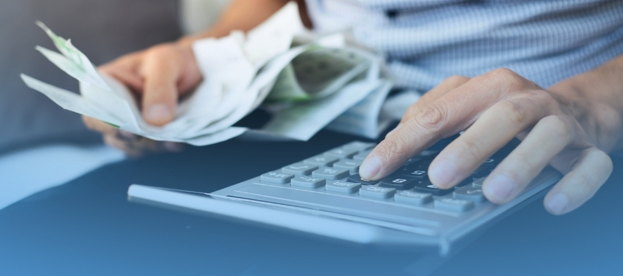 Contando dinero y usando calculadora para realizar factura